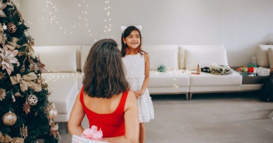 Mother giving her daughter a beautifully wrapped Christmas present