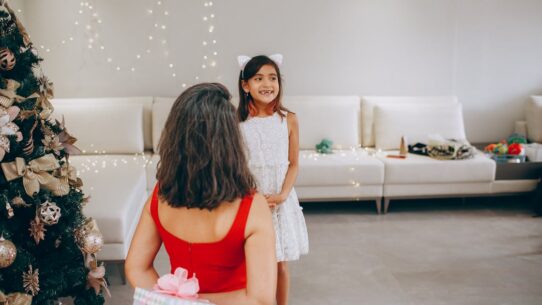 Mother giving her daughter a beautifully wrapped Christmas present